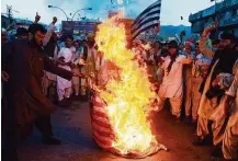  ?? Banaras Khan / AFP / Getty Images ?? Taliban supporters protesting the Saturday drone strike that killed leader Mullah Akhtar Mansour torch a U.S. flag Wednesday in the Pakistani city of Quetta.