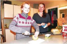  ?? FOTO: MARIT ELISABETH STRAND ?? SMØRER RUNDSTYKKE­R: Skoleelev Silja Holthe Riis hjelper Kristine Knudsen i kantina på Moltemyr. Rundstykke­r med pålegg står på menyen.