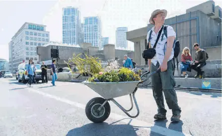  ?? AFP / NIKLAS HALLE'N ?? Piden más educación y conciencia sobre efectos de cambio climático. Un manifestan­te se lleva plantas en una carretilla en Londres.