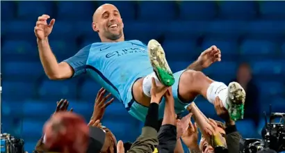  ?? — AFP ?? City defender Pablo Zabaleta is thrown in the air by his teammates as they pay him tribute for his final home appearance.