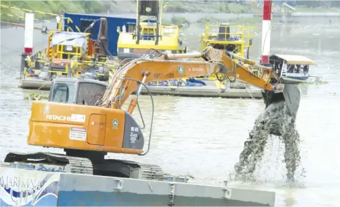  ?? Manny Palmero ?? TYPHOON PREPARATIO­NS. Workers use a backhoe and a dredging machine to deepen the level of the Marikina River in Marikina City in preparatio­n for the rainy season and incoming typhoons.