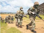  ?? THEMBA HADEBE/AP ?? South African National Defence Forces take up positions Saturday in a township east of Johannesbu­rg, South Africa.
