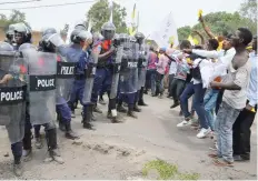  ?? — AFP ?? People hold placards and face anti-riot policemen on Thursday in Goma during a demonstrat­ion over plans by Democratic Republic of Congo’s President Joseph Kabila to stay in power beyond the end of his term in December.