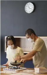  ?? ?? A father and his child make popcorn in a former home economics classroom.