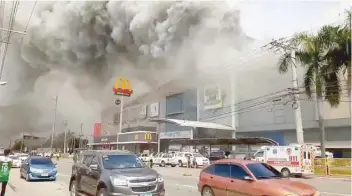  ?? — Reuters ?? Smoke rises from burning mall’s 3rd floor in Davao on Saturday, in this picture obtained from social media.