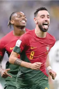  ?? — AFP ?? Portugal’s midfielder Bruno Fernandes (R) celebrates scoring his team’s second goal during the Qatar 2022 World Cup Group H match against Uruguay at the Lusail Stadium on Monday.