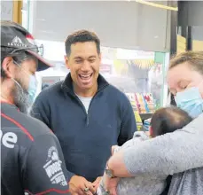  ?? ?? Former New Zealand cricket captain Ross Taylor signs a book for fans David and Patty Sheterline, pictured with 4-month-old Maliah Reti-Gibb, at Paper Plus in Levin.