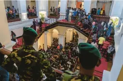  ?? RAFIQ MAQBOOL/AP ?? Army officers stand guard as people throng President Gotabaya Rajapaksa’s official residence Monday for the second day after it was stormed in Colombo, Sri Lanka.