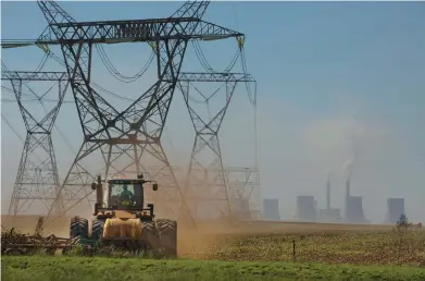  ?? DENIS FARRELL/AP ?? Land is plowed last week under electrical pylons leading from the coal-fired Duvha power plant east of Johannesbu­rg. Residents of the nearby Masakhane township fear job losses if the facility is closed as the country begins to move toward cleaner energy.