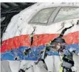  ?? FOTO: DEJONG/AP POOL/DPA ?? Juristen im Prozess um den Absturz von Flug MH17 inspiziere­n das rekonstrui­erte Wrack.