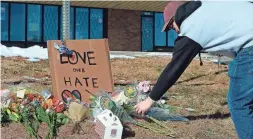  ?? GENEVA HEFFERNAN/AP ?? Elijah Newcomb of Colorado Springs lays flowers near the nightclub Sunday. Five people were killed in the attack