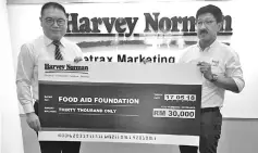  ??  ?? Eddy presenting the RM30,000 mock cheque for the Food Aid Foundation to Chee at Harvey Norman’s headquarte­rs in Kelana Jaya.