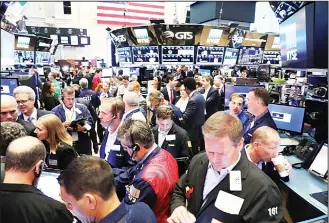  ??  ?? Traders work on the floor of the New York Stock Exchange (NYSE) on June 30, 2017 in New York City. Recovering some of their losses US stocks were up Friday morning with the Dow Jones industrial average up over 80 points.
(AFP)