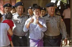  ?? THEIN ZAW / ASSOCIATED PRESS ?? Reuters journalist Wa Lone is escorted by Myanmar police upon arrival at the court for trial on the outskirts of Yangon, Myanmar, on Feb. 1.