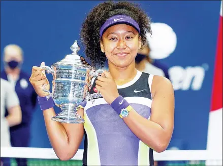  ??  ?? Naomi Osaka, of Japan, holds up the championsh­ip trophy after defeating Victoria Azarenka, of Belarus, in the women’s singles final of the US Open
tennis championsh­ips on Sept 12 in New York. (AP)