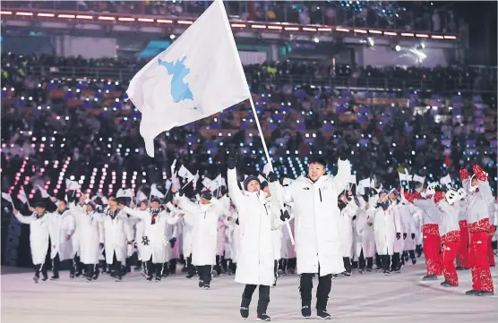  ?? Petr DaviD Josek / aP ?? Una imagen para el mundo: atletas de las dos Corea desfilan juntos, con una bandera de la silueta de la península coreana