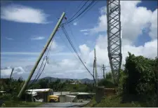  ?? CARLOS GIUSTI — THE ASSOCIATED PRESS FILE ?? file - In this file photo, an electric power pole leans over the road in the Piedra Blanca area of Yabucoa, Puerto Rico, a town still mostly without power since it was struck by Hurricane Maria on Sept. 20. Puerto Rico’s new governor announced on Sunday that she is suspending an upcoming $450,000contrac­t to rebuild and strengthen the island’s power grid destroyed by Hurricane Maria.