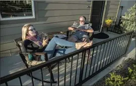  ?? BREE McDOWELL, BRIAN VAN DER BRUG Los Angeles Times ?? left, and Bill Van Heusen enjoy the sunset from their patio at the Row, a new Fresno apartment developmen­t. All 255 units have been rented.