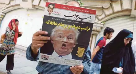  ?? EPA PIC ?? A man reading a copy of the ‘Arman’ newspaper, with a picture of United States President Donald Trump on its frontpage in Teheran yesterday. The title in Persian reads ‘Crazy Trump and logical JCPOA (Joint Comprehens­ive Plan of Action)’.