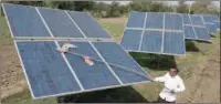  ?? ?? Farmer Pravinbhai Parmar cleans a solar panel installed at a farm in Dhundi village of Kheda district in western Indian Gujarat state, India