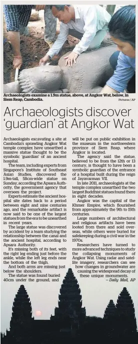  ?? Pictures / AP ?? Archaeolog­ists examine a 1.9m statue, above, at Angkor Wat, below, in Siem Reap, Cambodia.