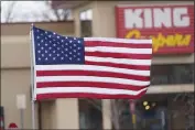  ?? DAVID ZALUBOWSKI — AP PHOTO ?? A flag flies from the fence put up around the parking lot at the scene of Monday’s mass shooting. More on the shooting,
PAGE A8.