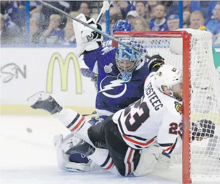  ?? CHRIS O’ MEARA/ THE ASSOCIATED PRESS ?? Chicago Blackhawks forward Kris Versteeg collides with Lightning goalie Ben Bishop Wednesday during the second period of Game 1 of the Stanley Cup Final in Tampa, Fla.