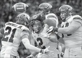  ?? Kyle Robertson Columbus Dispatch ?? OHIO STATE running back J.K. Dobbins, center, celebrates with teammates after his touchdown run gave the Buckeyes the lead late in the third quarter.