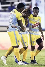  ??  ?? Waterhouse FC players Shawn Lawes (left) and Cardel Benbow (right) console teammate Kemar Beckford after his penalty shootout miss against Portmore United in the Red Stripe Premier League final at the National Stadium on Monday night.