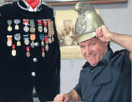  ?? Photo: JOHN BISSET/FAIRFAX NZ ?? Head gear: Timaru senior firefighte­r Alastair Thornley wearing the 1898 silver helmet presented to former Timaru Fire Brigade superinten­dent Peter Campbell.