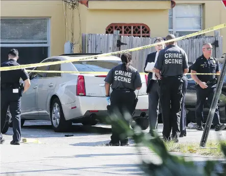  ?? HECTOR GABINO/ THE ASSOCIATED PRESS ?? Miami- Dade police work the scene after a shootout Monday involving the two teenage sons of Roxanne Dube, Canada’s counsel general to Florida. Marc Wabafiyeba­zu, 15, is in custody, while his brother Jean, 17, died from injuries suffered in the shootout.
