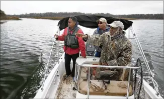  ?? PHOTOS BY STEPHEN B. MORTON / AJC ?? Hanif Haynes (foreground), a local historian in Savannah, stops his boat earlier this month near the mouth of Runaway Negro Creek near Pin Point. With him are Savannah State University historian Jamal Touré (left) and state Sen. Lester Jackson,...