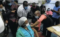  ?? Picture: Alon Skuy ?? Dr Onicca Khobo-Mpe vaccinates a health worker as Gauteng premier David Makhura looks on at Steve Biko Academic Hospital, Pretoria.