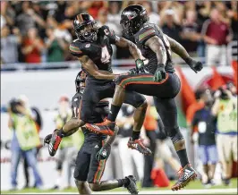  ?? ANDRES LEIVA / THE PALM BEACH POST ?? Defensive lineman Joe Jackson (right) and safety Jaquan Johnson (4) celebrate after an intercepti­on by Johnson in the win over Virginia Tech.