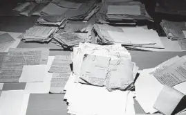  ??  ?? Torn-up documents that the East German secret police hoped to destroy in 1989 and 1990 are reconstruc­ted by “puzzlers.” Some 500 sacks of papers have already been pieced together.