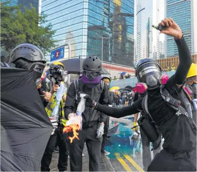  ??  ?? An anti-government protester throws a Molotov cocktail during a demonstrat­ion near Central Government Complex in Hong Kong.