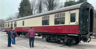  ?? Daniel Smith ?? RMB S1874 has arrived at the Ecclesbour­ne Valley Railway from the Bodmin & Wenford Railway, where it will initially be used as a static catering vehicle to replace Mk.2f 72617. During a light snowfall, volunteers inspect the newly-delivered coach at Wirksworth. It has since been moved into the restoratio­n shed for work to begin.