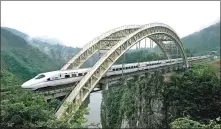  ?? TENG JUN / FOR CHINA DAILY ?? A bullet train passes through a bridge in Enshi, Central China’s Hubei province on July 1, 2014. Enshi is the first autonomous prefecture in China that had access to the high- speed railway, which helped lift the region out of poverty.