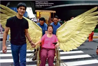  ?? ROY REGALADO ?? IO Regalado marches with his Ibong Malaya creation, wings flapping, his lola on it.