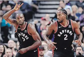  ?? NATHAN DENETTE THE CANADIAN PRESS ?? Raptors’ Serge Ibaka (9) celebrates a basket against the Charlotte Hornets with Kawhi Leonard in the first half in Toronto on Monday night. The Raptors won the game, 127-106.