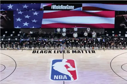  ??  ?? Members of the New Orleans Pelicans and Utah Jazz kneel together around the Black Lives Matter logo before Thursday’s first game. Photograph: Ashley Landis/USA Today Sports