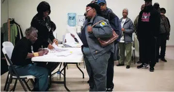  ?? JIM WATSON / AFP / GETTY IMAGES ?? A voter picks up her ballot after standing in a long line at the Beulah Baptist Church polling station in Montgomery, Ala., last Tuesday. Exit polls showed black voters comprised 28 per cent of the vote in the state’s special Senate election last week,...
