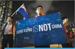  ??  ?? HONG KONG: A flag that reads ‘Hong Kong is not China’ is displayed by a local football fan outside the stadium in Hong Kong. A new law that punishes disrespect for China’s national anthem with up to three years’ imprisonme­nt may also apply to Hong Kong...