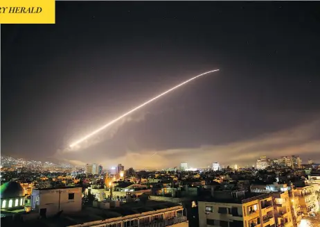  ?? HASSAN AMMAR / THE ASSOCIATED PRESS ?? Explosions and anti-aircraft fire light up the skies over the Syrian capital of Damascus early Saturday morning as the U.S. launches an attack on President Bashar al-Assad’s forces. The strikes by U.S. and coalition forces came in retaliatio­n for the...