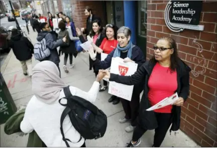  ?? MATT ROURKE — THE ASSOCIATED PRESS ?? Teacher Pia Martin greets students as they arrive to school at the Science Leadership Academy as teachers take part in “A Day Without a Woman” demonstrat­ion in Philadelph­ia, Wednesday. Organizers of January’s Women’s March are calling on women to stay...