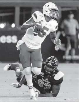  ?? AL DIAZ adiaz@miamiheral­d.com ?? Hurricanes quarterbac­k Jarren Williams scrambles as Panthers defensive lineman Teair Tart (93) misses the tackle in the first quarter.