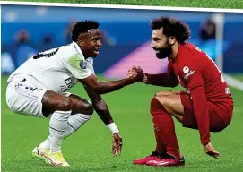  ?? EPA ?? Getting to grips: Salah helps Vinicius up as Klopp’s side are undone by Real again