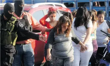  ?? MARVIN RECINOS / AFP / GETTY IMAGES ?? Alleged members of the MS-13 gang are presented to the press in San Salvador in 2016 after a police operation aimed at dismantlin­g the gang’s money laundering schemes.