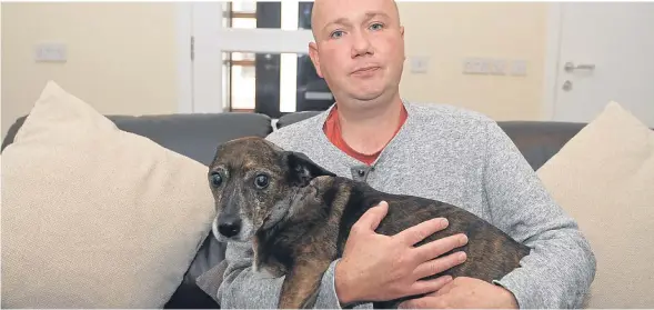 ??  ?? Chris Rae pictured at home with his dog Dino shortly after the attack in September.