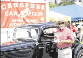  ?? CHAD RHYM / CHAD.RHYM@AJC.COM ?? Mike Garrett won the first AJC Creepers Club Cup on Saturday. His 1933 Ford coupe was honored as the most solid car at the Marietta event. Hundreds of car lovers and 300 classic cars were on hand for the children’s charity benefit.